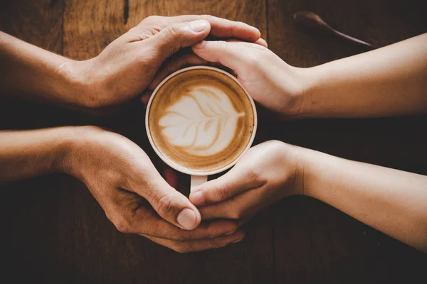 Secangkir kopi di tangan seorang pria dan seorang wanita . — Stok Foto