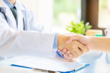 Doktor ve hasta ofiste el sıkışma, sağlık ve bir