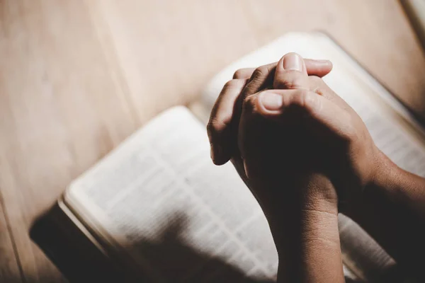 Τα χέρια ήταν σε προσευχή σε μια Αγία Γραφή στην εκκλησιαστική αντίληψη για την πίστη. — Φωτογραφία Αρχείου