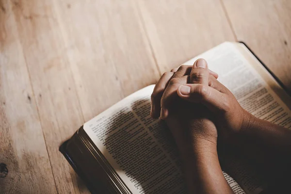 Spiritualité et religion, les mains jointes dans la prière sur un Saint Bibl — Photo