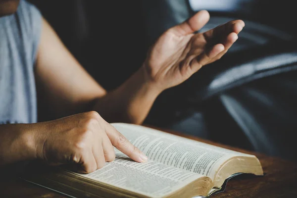 Spiritualité et religion, les mains jointes dans la prière sur une Sainte Bible — Photo