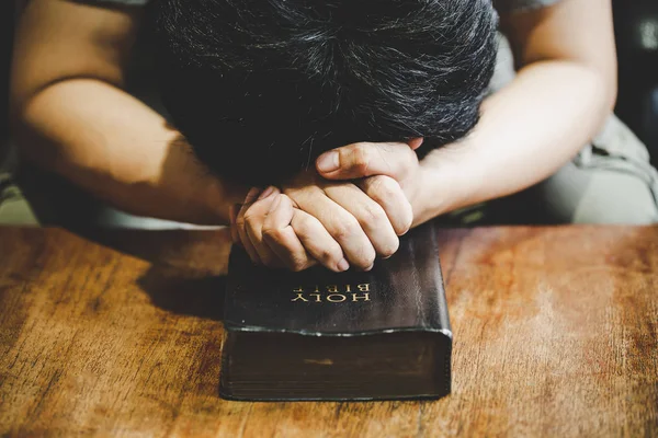 Espiritualidad y religión, Manos dobladas en oración sobre una Sagrada Biblia —  Fotos de Stock