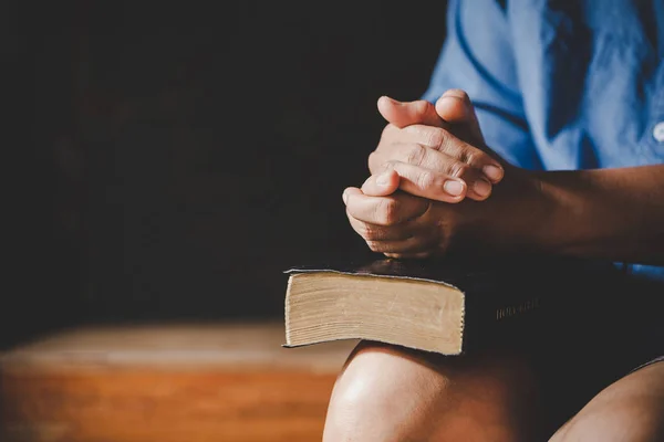 Espiritualidad y religión, Manos dobladas en oración sobre una Sagrada Biblia — Foto de Stock