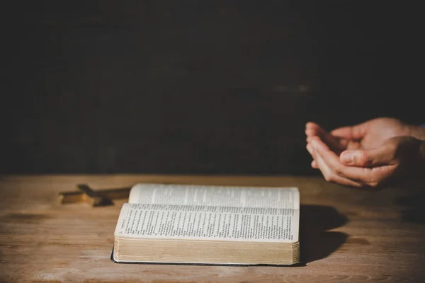 Espiritualidad y religión, Manos dobladas en oración sobre una Sagrada Biblia — Foto de Stock