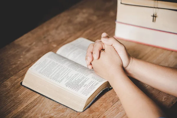 Espiritualidad y religión, Manos dobladas en oración sobre una Santa Biblia —  Fotos de Stock