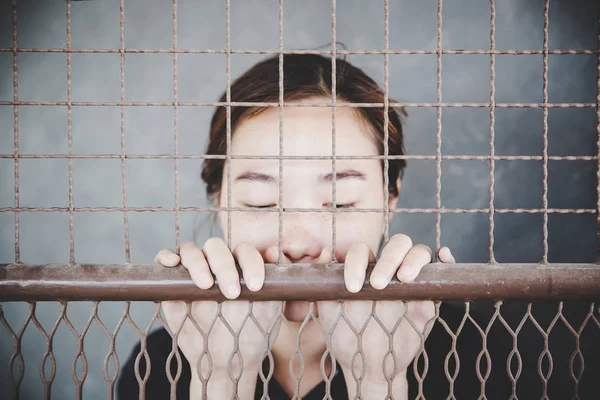 Krásná mladá dívka za mřížemi — Stock fotografie