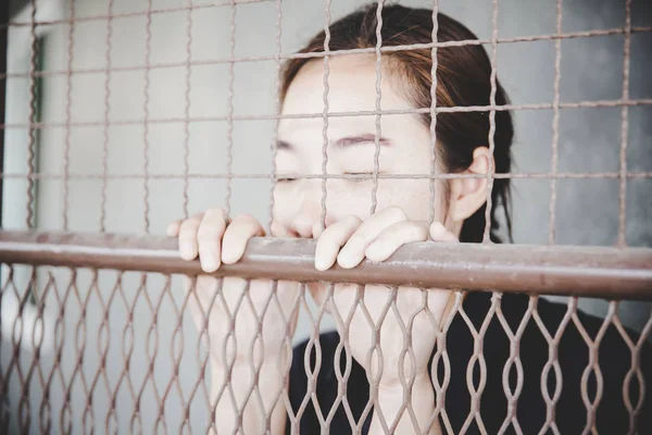 Krásná mladá dívka za mřížemi — Stock fotografie