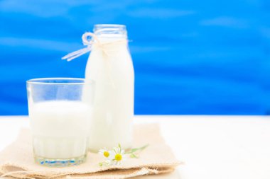 Şişe süt ve cam masada