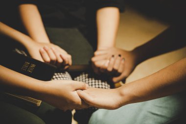 Üç kişi birlikte dua edip Tanrı 'yı överek İncil' i kopyalayıcılarla paylaşıyorlardı..