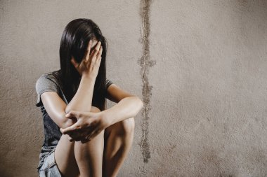 Stresli ve umutsuz bir kadın yerde oturuyor, istismar kavramı