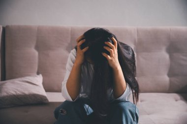 Boş karanlık odada kederli bir adam, elleri ile yüzünü kapatan depresif genç bir kadın. Üzüntülü yüzüyle başa çıkan genç bir kadın. Akıl sağlığı konsepti. Sıkıcı üzgün sinirli sinirli.