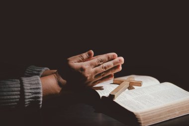 Elleri kutsal İncil 'in üzerine katlanmış, inancı, bağlılığı, Hristiyanlığı, umudu ve manevi gücü simgeleyen dualar. İbadet, meditasyon ve Tanrı 'ya güvenme kavramı..