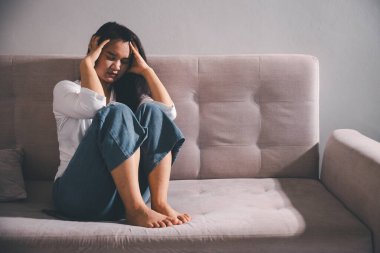 Boş karanlık odada kederli bir adam, elleri ile yüzünü kapatan depresif genç bir kadın. Üzüntülü yüzüyle başa çıkan genç bir kadın. Akıl sağlığı konsepti. Sıkıcı üzgün sinirli sinirli.