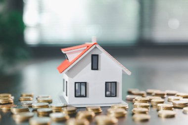 Model ev, yığınla para, hesap makinesi, ahşap masadaki mali belgeler emlak yatırımı ve ipotek planlama, mali büyüme ve stratejik planlama stratejilerini ön plana çıkarma.