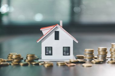 Model ev, yığınla para, hesap makinesi, ahşap masadaki mali belgeler emlak yatırımı ve ipotek planlama, mali büyüme ve stratejik planlama stratejilerini ön plana çıkarma.