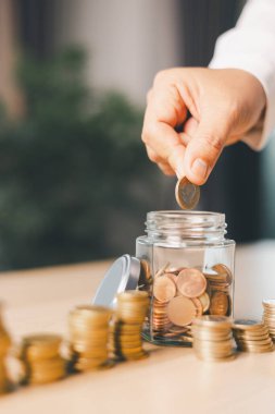 Elle para tasarruf kavanozuna konur, akıllı finans, yatırım, bankacılık uygulamalarının parayı, parayı, parayı, para birimini finansal zenginliğe dönüştürmesini ve iş büyümesini ve ekonomiyi nasıl güçlendirdiğini temsil eder..