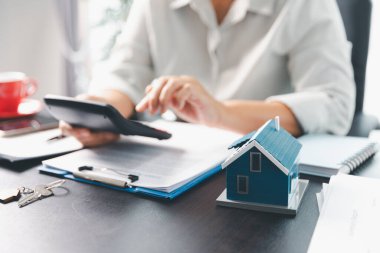 Emlakçı, müşteri temsilciliğine ev almayı kabul etti. Ev modeli, emlakçı, ev, sigorta, kredi emlak geçmişi için kontrat imzalamak isteyen müşteri. Kavram anlaşması.