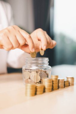 Elle para tasarruf kavanozuna konur, akıllı finans, yatırım, bankacılık uygulamalarının parayı, parayı, parayı, para birimini finansal zenginliğe dönüştürmesini ve iş büyümesini ve ekonomiyi nasıl güçlendirdiğini temsil eder..