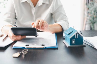 Emlakçı, müşteri temsilciliğine ev almayı kabul etti. Ev modeli, emlakçı, ev, sigorta, kredi emlak geçmişi için kontrat imzalamak isteyen müşteri. Kavram anlaşması.