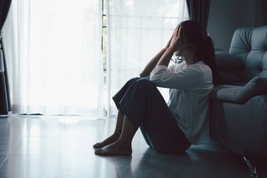 Evdeki kanepede oturan umutsuz, yorgun kız. Genç kadın oturma odasında oturuyor, üzgün ve depresif hissediyor. Psikolojik bir sorun. Depresyon ve yalnızlık kavramı.