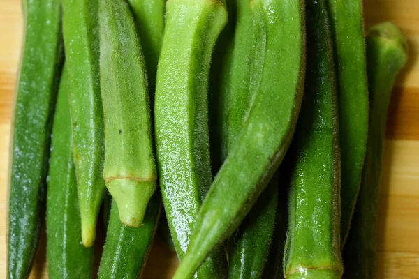 Dámské Prsty Nebo Okra Zelenina Přes Dřevěný Stůl Pozadí — Stock fotografie