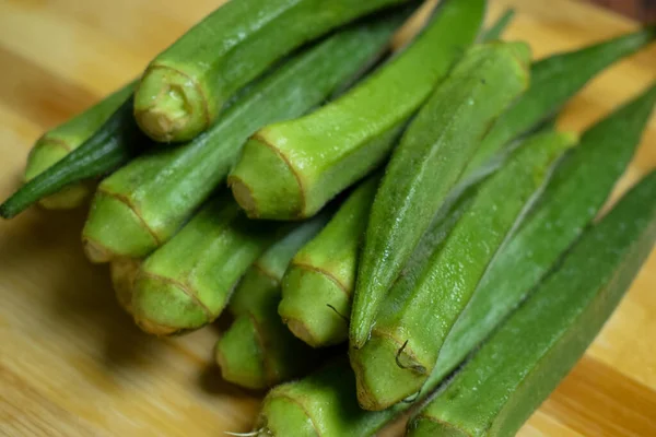 Dámské Prsty Nebo Okra Zelenina Přes Dřevěný Stůl Pozadí — Stock fotografie