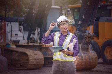 Kadın mühendisler inşaat işçisi. Foreman inşaat alanında kazıcıyla birlikte çalışıyor..