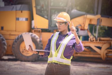 Kadın mühendisler inşaat işçisi. Foreman inşaat alanında kazıcıyla birlikte çalışıyor..