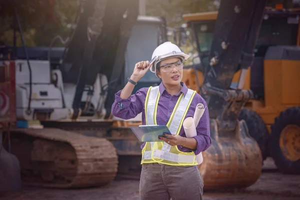 Kadın mühendisler inşaat işçisi. Foreman inşaat alanında kazıcıyla birlikte çalışıyor..