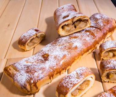 Elmalı turta, ahşap bir arka planda parçalara ayrılmış, yakın plan.