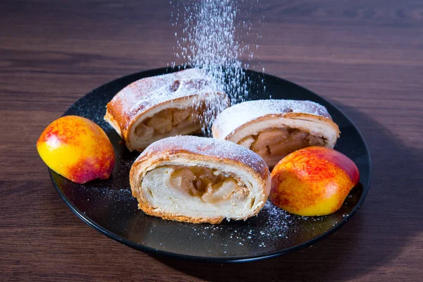 Strudel Mit Äpfeln Auf Schwarzem Teller Pfirsichen Mit Puderzucker Bestreut — Stockfoto