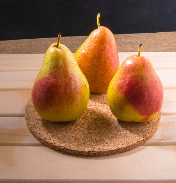 Three pears on a prop stand, closeup