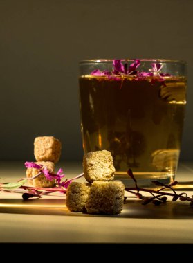  Bir çiçekle üç kamış şekeri, bir bardak içki.