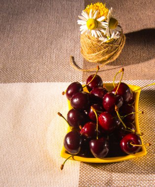  Kirazlı çay tabakları, masada bir buket çiçek.