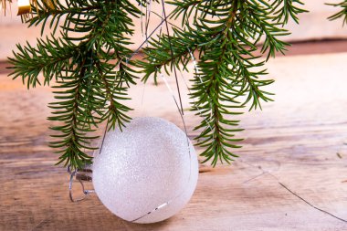 Oyuncak dalları, beyaz cam top ve tahta bir arka plan. Noel kartı.