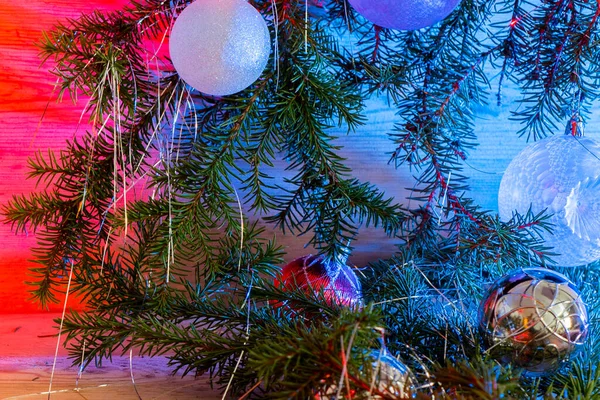Oyuncak dalları, cam toplar, parlak ahşap arka planda süsler. Noel kartı.