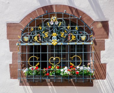 Çiçekli ve işlenmiş demir parmaklıklı pencere, Freiburg, Almanya 19.07.2017