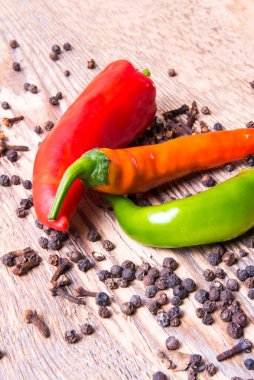 Ahşap bir masada bezelyeli acı yeşil kırmızı kapsika.