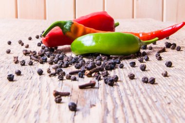 Ahşap bir masada bezelyeli acı yeşil kırmızı kapsika.