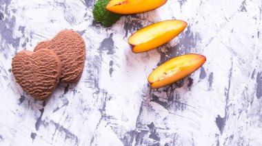 Kalp şeklinde kurabiyeler ve nane yapraklı erik dilimleri.