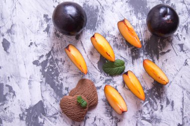 Kalp şeklinde kurabiyeler ve nane yapraklı erik dilimleri.