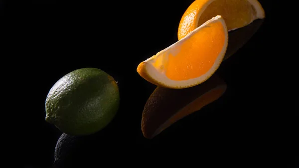 Duas Fatias Laranja Limão Verde Inteiro Fundo Preto — Fotografia de Stock