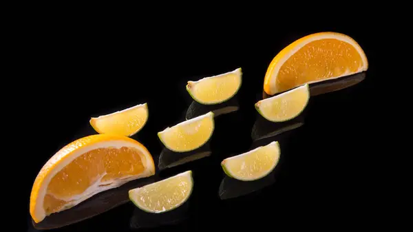 Két Narancssárga Szeletek Citrom Szeletek Egy Fekete Háttér Közeli — Stock Fotó