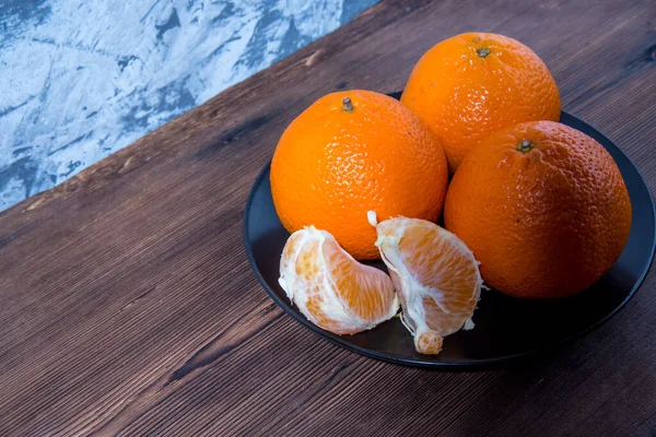 Mandarinenscheiben Mandarine Auf Schwarzem Teller Auf Altem Naturholztisch Seitenansicht Nahaufnahme — Stockfoto