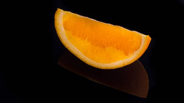 Orange slices on a black background with reflection,background,postcard,advertising