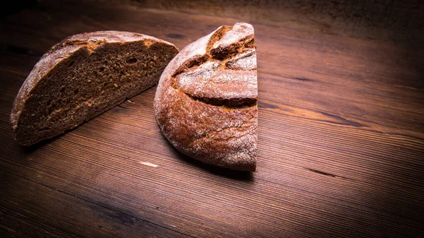 Een Brood Van Rogge Tweeën Gesneden Een Oude Houten Tafel — Stockfoto