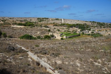 Muhteşem dağ manzarası, klasik binalar ve L-Ahrax, Mellieha, Malta 'daki egzotik bitki örtüsü..
