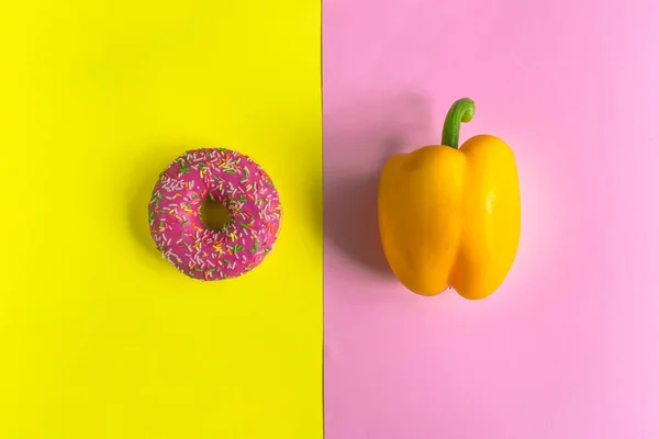 Kremalı ahududu çöreği ve sarı pembe arka planda dolmalık biber. Sağlıklı ve sağlıksız yiyecekler. Üst görünüm.
