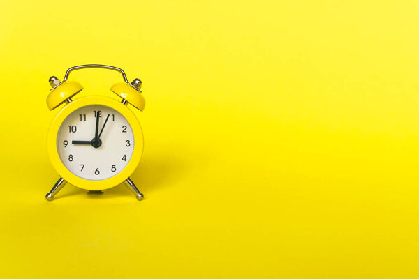 Ringing twin bell vintage classic alarm clock isolated on yellow background. Rest hours time of life good morning night wake up awake concept. Flat lay top view copy space