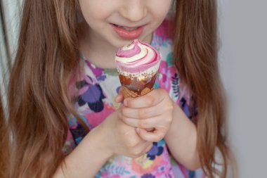 Yedi yaşında bir kız dondurma yiyor. Yakın plan..